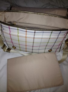 Coach Diaper bag comes with a changing pad.  Thank you all for voting and choosing the bag.  I love that it isn't cloth on the outside which makes for easy wipe downs.  It has a lot pockets too which I like.  The things I don't like are: its a bit slender making it hard to pack a lot of things in it and it is white...and you know I can't get the Coach bag dirty LOL.  But I LOVE that its stylish, I would carry this bag as a purse if it was a little smaller so it meets both Genesis and Mommy's needs.